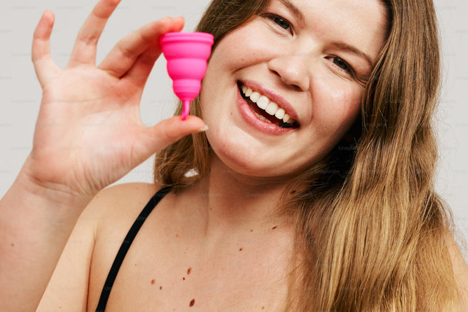 Woman holding pink wellness product - complete guide to UTIs
