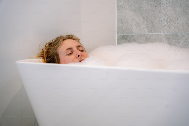 Woman relaxing in bath - vaginal pH balance and wellness